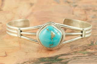 Genuine Castle Dome Turquoise set in Sterling Silver Bracelet. The Castle Dome Turquoise Mine is located about 30 miles from the Sleeping Beauty Mine, near Globe, Arizona. The Castle Dome Mine has not been in operation since the early 1970s. Created by Navajo Artist Milton Lee. Signed by the artist.